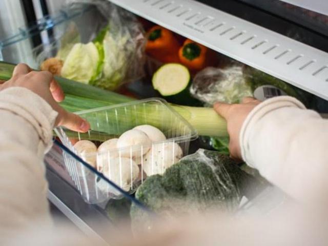 Picking vegetable from the fridge