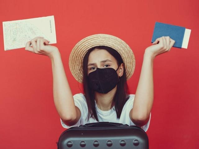 woman wearing face masks and holding passport