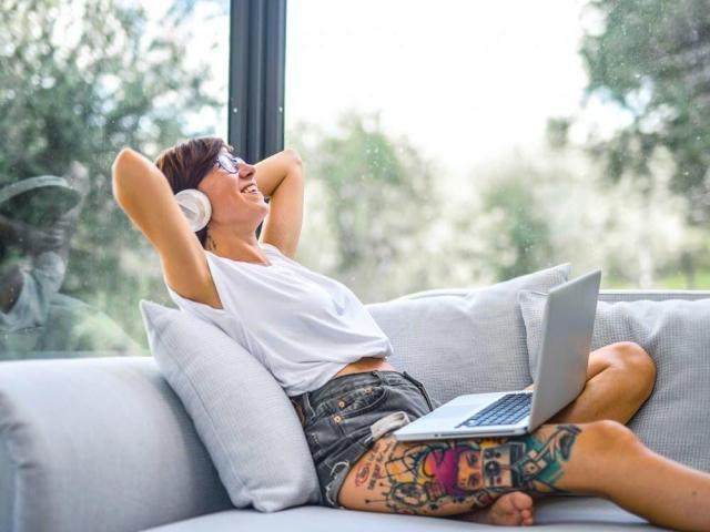woman sitting on couch with laptop