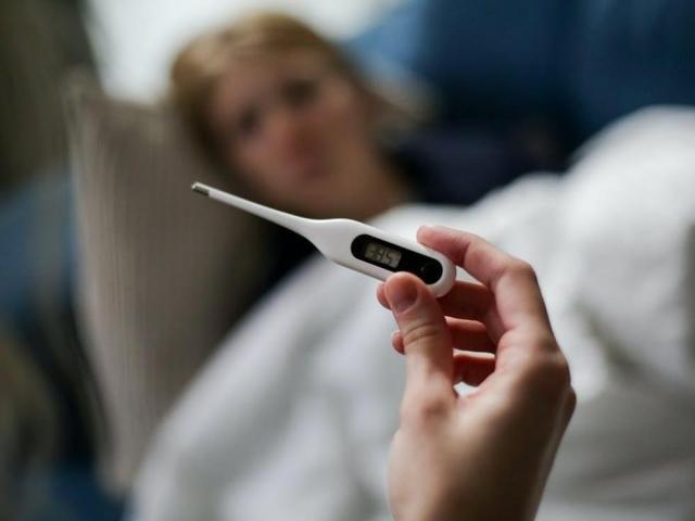 woman in bed and thermometer