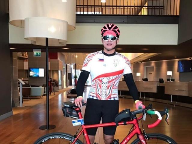 Zoren Legaspi in his full cycling suit and a bike