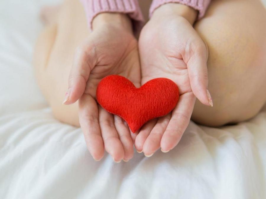 woman holding heart stuffed toy