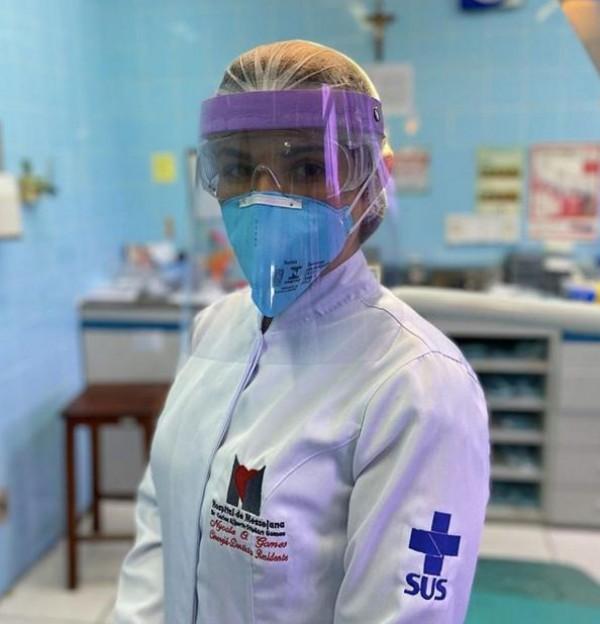 A medical professional wears goggles and a face shield