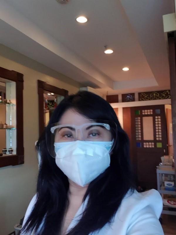 Dr Grace Beltran wears her full face shield and mask inside the clinic