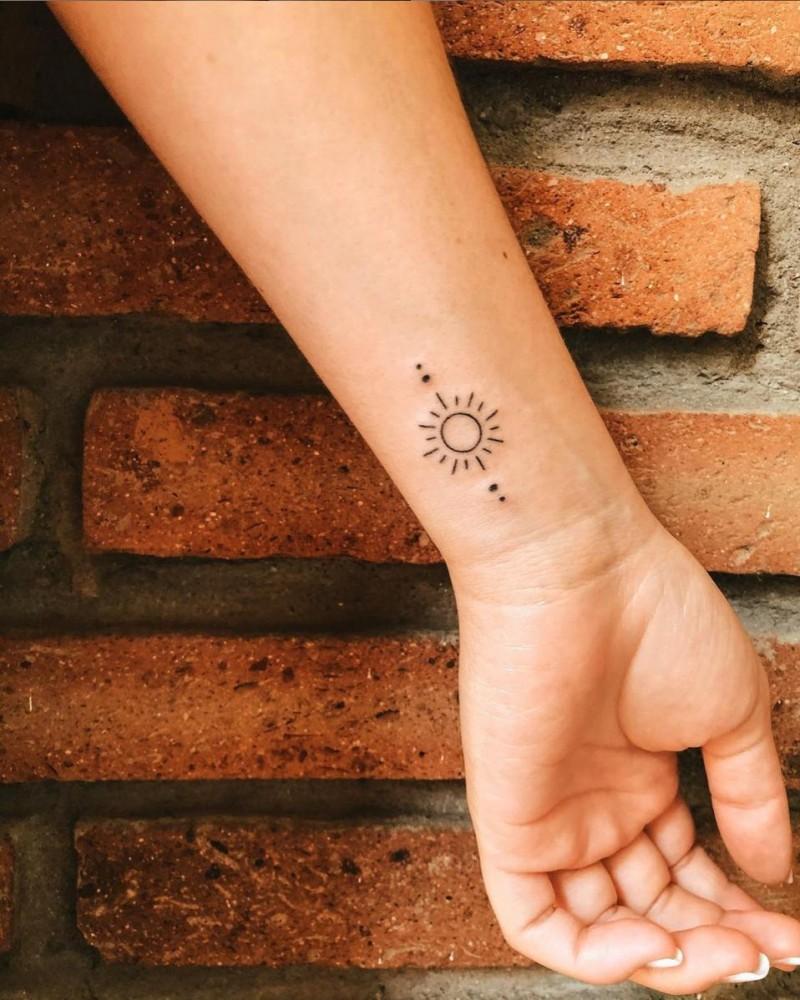 Minimalist sun tattoo on the hip