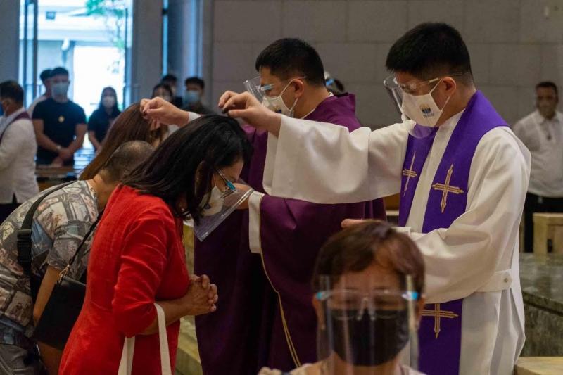 priest sprinkling ashes