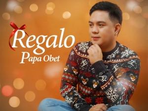 Regalo cover art, Papa Obet wearing Christmas sweater and Indian seated